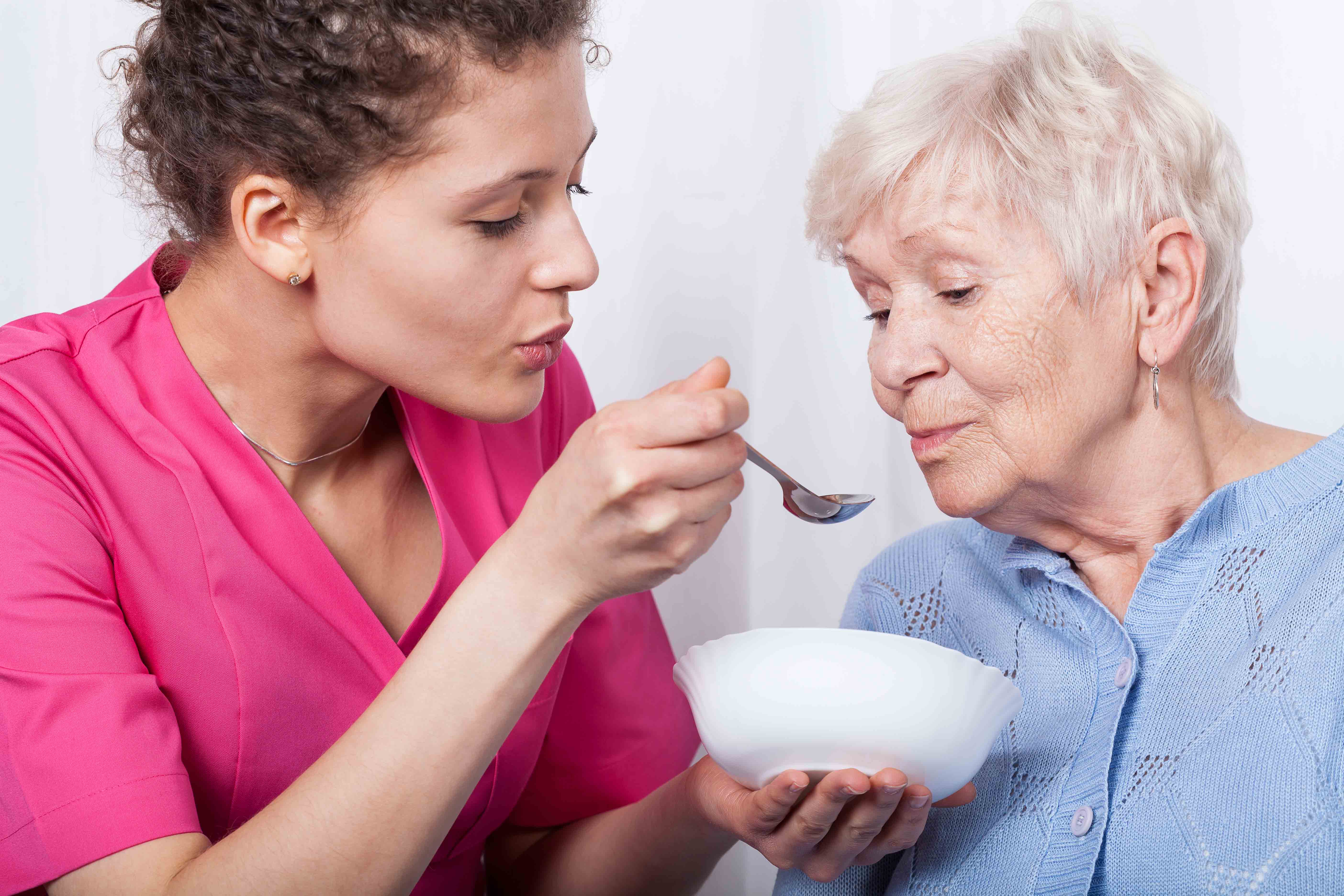 A Stockwellcare carer holding the hand of a service user with dementia
